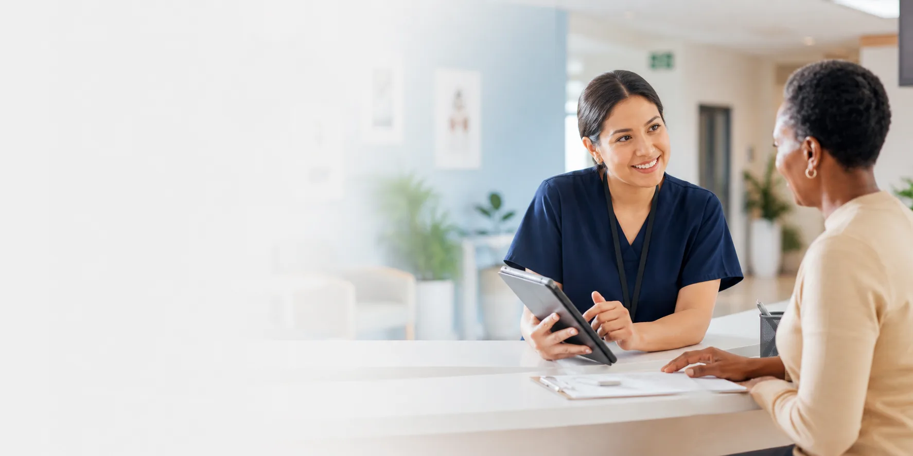 Healthcare staff member answering patient questions at a community clinic front desk